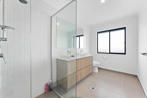 a white bathroom with a sink and a mirror at Homenest in Gledswood Hills