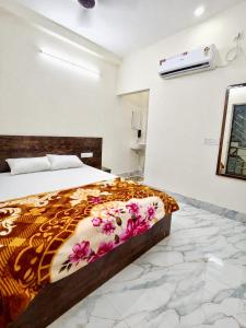 a bedroom with a bed with a colorful blanket at Hotel Sada Shiv Inn in Deoghar