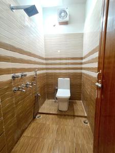 a bathroom with a toilet and a shower at Hotel Sada Shiv Inn in Deoghar