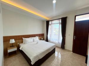 a bedroom with a large bed and a window at Pantai Ayu Homestay in Padangbai