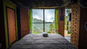 a bedroom with a bed and a large window at Habitacion corralito in San Jose del Pacifico