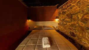 a bed in a room with a stone wall at Habitacion corralito in San Jose del Pacifico