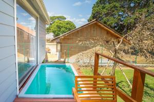 a porch with a swimming pool and a wooden chair at Leopard Inn Arugam Bay in Arugam Bay