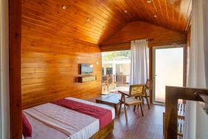 a bedroom with a bed and a wooden ceiling at Leopard Inn Arugam Bay in Arugam Bay