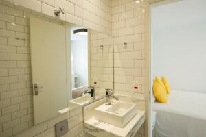 
a bathroom with a sink, mirror and bath tub at Sugar Loft Apartments in Rio de Janeiro
