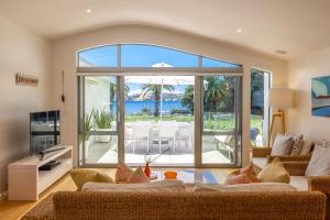 a living room with a view of the ocean at Beachfront 25 The Strand Moana in Waiheke Island