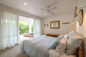 a bedroom with a bed and a large window at Beachfront 25 The Strand Moana in Waiheke Island