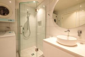 a bathroom with a sink and a shower at Beachfront 25 The Strand Moana in Waiheke Island +16 photos