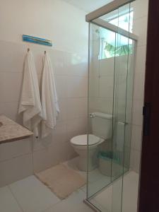 a bathroom with a toilet and a glass shower at Solar das pérolas Búzios 1 in Búzios +12 photos