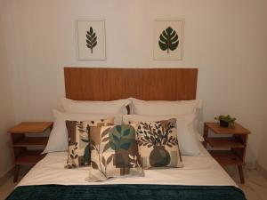 a bed with a wooden headboard and pillows on it at Solar das pérolas Búzios 1 in Búzios