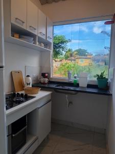 a kitchen with a window and a counter top at Solar das pérolas Búzios 1 in Búzios