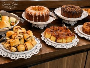 a table with several different types of cakes and pastries at Hotel Pousada Santa Ceia in Aparecida