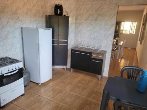 a kitchen with a refrigerator and a table with wine glasses at Casa Correntina BA 3 quartos in Correntina