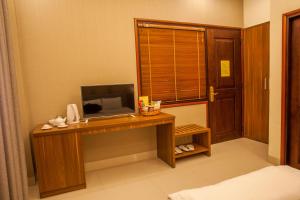 a room with a desk with a television on it at Trieu Khang Hotel gần sân bay Cam Ranh near Cam Ranh Airport in Cam Ranh