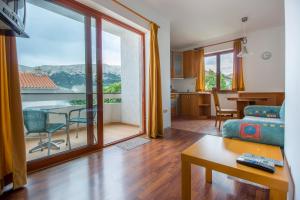 a living room with a couch and a table with a view at Marija Big & Comfortable in Baška