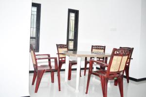 a table and four chairs and a table and chairsktop at Lasya Residence in Trincomalee