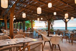 a restaurant with tables and chairs and a view of the ocean at Sofitel Kia Ora Moorea Beach Resort in Maharepa