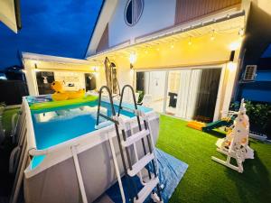 a backyard with a swimming pool and a playground at พิภูตะวัน วิลล่า in Ban Luam