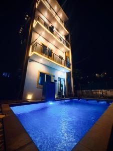 a building with a swimming pool in front of it at night at Dreamy beach villa in Pondicherry