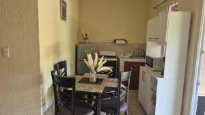 a kitchen with a table with chairs and a refrigerator at Residencial Acropolis in Sonsonate