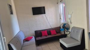 a living room with a couch and two chairs at Residencial Acropolis in Sonsonate
