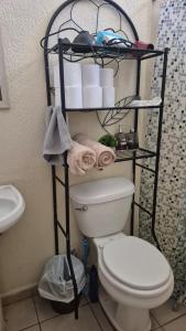 a bathroom with a toilet and a shelf with toilet paper at Residencial Acropolis in Sonsonate +5 photos