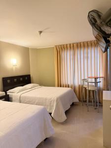 a hotel room with two beds and a table at "HOSTAL LA NOCHE" -Pisco in Pisco