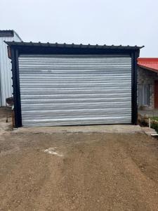 a large metal garage door on a dirt road at Apartamento 201 in Colonia Valdense