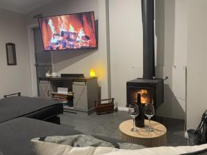 a living room with a fireplace and a flat screen tv at Riverfront, Tiny Home in Natural Bush in Bridgetown