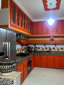 a kitchen with red cabinets and a stove top oven at Tafoukt 2 in Kasba Aït Youdi