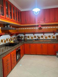 a kitchen with red cabinets and a sink at Tafoukt 2 in Kasba Aït Youdi