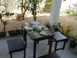 a table with cups and dishes on top of it at Villa Aloe Vera- Signature Rooms in Weligama