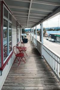 a porch with two red chairs and a table at Hampden Hotel Murchison in Murchison +19 photos
