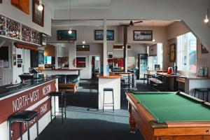 a pool table in a room with a bar and tables at Hampden Hotel Murchison in Murchison