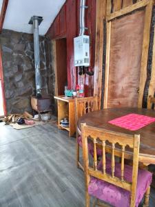 a dining room with a table and a stove at Refugio de montaña Küme Mongüen in Malalcahuello