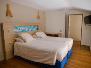a bedroom with a large bed with white sheets and pillows at Le Pacifik Kone in Koné +19 photos