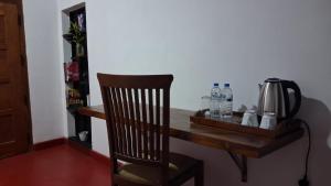 a wooden desk with a chair next to a wall at Sigiri Grand Villa in Sigiriya