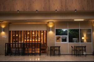 a bar in a building with tables and chairs at JT Place Buriram in Buriram