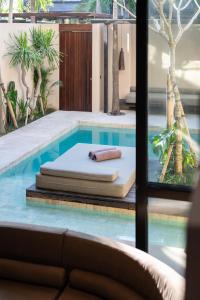 a bed sitting next to a swimming pool at The Sirocco Villas Bingin by Sandara in Bingin Beach