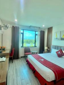 a hotel room with a large bed and a desk at Rosy Hotel Dương Nội in Hà Ðông