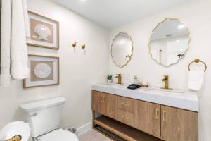 a bathroom with a sink and a toilet and mirrors at Blanco Bay Key in Duck Key +27 photos