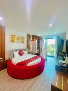 a bedroom with a large bed with a red circular bedvisor at Rosy Hotel Dương Nội in Hà Ðông