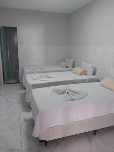 a group of three beds in a room at Pousada Triângulo in Juazeiro do Norte