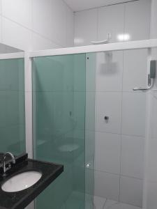 a bathroom with a glass shower and a sink at Pousada Triângulo in Juazeiro do Norte