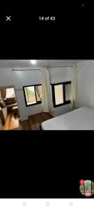 a picture of a bedroom with a bed and two windows at Gigi's transient house in Baguio