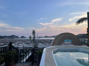 a hot tub on a balcony with a view of a city at The One Hostel & Rooftop Bar Catba in Cat Ba