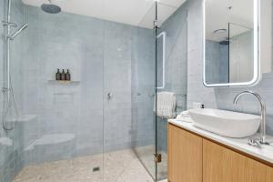 a bathroom with a sink and a glass shower at Urban Rest Melbourne in Melbourne