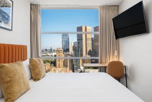 a hotel room with a large bed and a large window at Urban Rest Melbourne in Melbourne