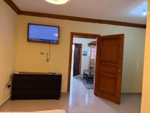 a living room with a flat screen tv on the wall at Aparta hotel doble in Higuey
