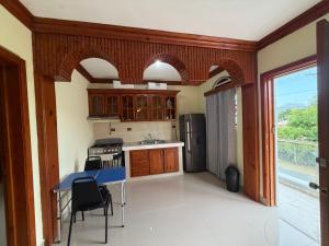 a kitchen with wooden cabinets and a blue table at Aparta hotel doble in Higuey